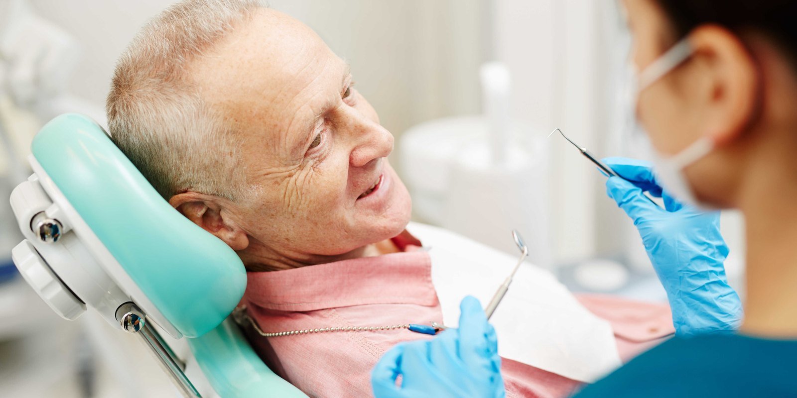 Older adult patient discussing denture options with the dentist at University Dental Group in Orlando, FL